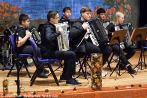 Ein großes Akkordeonensemble musiziert.