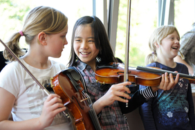 Drei Jugendliche üben Violine