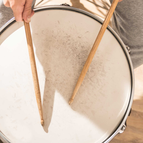 Spielende Hände mit Drumsticks auf einer Snaredrum