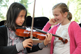 Zwei Jugendliche üben Violine